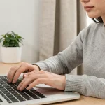 Femme utilisant le raccourci clavier Commande+Q pour fermer une application sur MacBook Pro